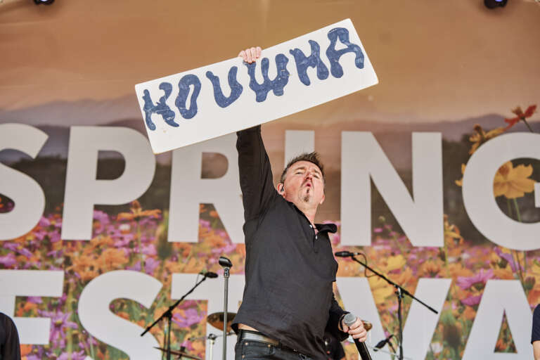 A singer holds up a “Kouma” sign on stage during a Spring Festival concert.