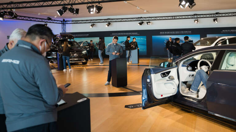 Participants engaging with the Mercedes-Benz car lineup during the training event.