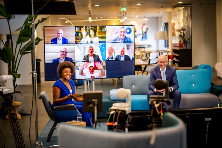 Hybrid broadcast set with in-person and remote participants.