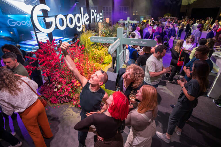 Participants prenant un selfie dans un espace scénographié aux couleurs de Google Pixel, lors d’un événement BtoB